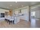 Modern white kitchen featuring a center island, pendant lighting, and wood floors at 14445 Hop Clover Trl, Parker, CO 80134