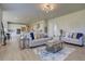 Bright and airy living room with wood floors, sofas and kitchen in the background at 14445 Hop Clover Trl, Parker, CO 80134