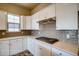 Kitchen features gas cooktop, white cabinets, and gray tile backsplash at 841 W 128Th Pl, Westminster, CO 80234