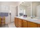 Bright bathroom featuring a double vanity, a large mirror, and an enclosed shower at 21062 Hawthorne Ln, Parker, CO 80138