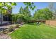 Lush backyard with a well-maintained lawn, mature trees, patio seating, and a charming garden area at 5694 S Pagosa Ct, Centennial, CO 80015
