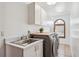Well-lit laundry room with modern washer and dryer, sink, and storage cabinets at 5694 S Pagosa Ct, Centennial, CO 80015