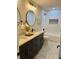 Bathroom featuring double sinks with black cabinets, round mirrors, and a separate tub and shower at 9810 Venneford Ranch Rd, Highlands Ranch, CO 80126