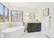 Modern bathroom with a soaking tub, vanity, and a window offering natural light at 9810 Venneford Ranch Rd, Highlands Ranch, CO 80126