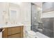 Modern bathroom features a glass enclosed shower, wood-trimmed vanity, and white countertops at 9810 Venneford Ranch Rd, Highlands Ranch, CO 80126