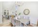 Bright dining room features a large table, statement chandelier and a view into the living room at 9810 Venneford Ranch Rd, Highlands Ranch, CO 80126