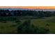 Scenic evening landscape featuring a golden sky, distant mountains, and lush green fields, offering a tranquil view at 9810 Venneford Ranch Rd, Highlands Ranch, CO 80126