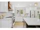 Bright kitchen features white cabinetry, stainless steel appliances, light countertops, and hardwood floors at 9810 Venneford Ranch Rd, Highlands Ranch, CO 80126
