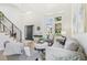Bright and inviting living room showcasing a modern staircase, large windows, and stylish decor at 9810 Venneford Ranch Rd, Highlands Ranch, CO 80126