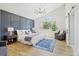 Bright main bedroom featuring a blue accent wall, chandelier, and sun-filled window views at 9810 Venneford Ranch Rd, Highlands Ranch, CO 80126