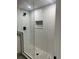 Modern shower with sleek white subway tiles, glass enclosure, and elegant mosaic flooring at 9810 Venneford Ranch Rd, Highlands Ranch, CO 80126