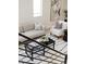 Living area showcasing modern furniture, including a sofa, chair, and a coffee table with a black and white rug at 1390 S Jasmine Way, Denver, CO 80224