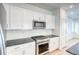 Bright kitchen featuring white cabinets, stainless steel appliances, gas range, and subway tile backsplash at 21242 E 63Rd Dr, Aurora, CO 80019