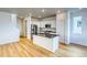 Bright kitchen featuring stainless steel appliances, island with dark countertop, and hardwood floors at 21242 E 63Rd Dr, Aurora, CO 80019