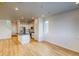 Open concept living room with kitchen island, stainless steel appliances, and hardwood floors at 21242 E 63Rd Dr, Aurora, CO 80019