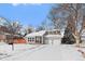 Charming updated home with a snowy front yard and attached garage at 6593 Owens Ct, Arvada, CO 80004