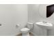 Powder room featuring a pedestal sink, round mirror, and toilet creating a functional space at 2351 Monte Vista St, Fort Lupton, CO 80621