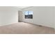 Bright bedroom featuring neutral carpet, white walls, trim, and a window offering neighborhood views at 2351 Monte Vista St, Fort Lupton, CO 80621