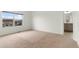 Well-lit bedroom with plush carpet, a window offering neighborhood views, and an attached bathroom at 2351 Monte Vista St, Fort Lupton, CO 80621