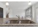 Close-up on kitchen island granite countertop featuring a stainless steel double sink and faucet at 2351 Monte Vista St, Fort Lupton, CO 80621