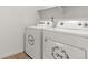 Bright laundry room featuring a white washer and dryer, shelving and neutral paint at 2351 Monte Vista St, Fort Lupton, CO 80621