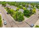 Neighborhood aerial view showcases lush trees surrounding houses on a sunny day with cracked street corner at 6506 S Robb Way, Littleton, CO 80127