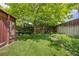 Beautiful backyard features lush green grass, mature trees, and privacy fence at 6506 S Robb Way, Littleton, CO 80127