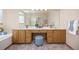 Bathroom featuring double vanity, large mirror, and vanity seating area at 6506 S Robb Way, Littleton, CO 80127