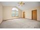 Large bedroom with neutral carpet, ceiling fan, vaulted ceilings, and a bright window at 6506 S Robb Way, Littleton, CO 80127