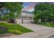 Charming two-story home with a well-manicured lawn, mature trees, and a spacious three-car garage at 6506 S Robb Way, Littleton, CO 80127