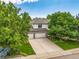 Aerial view of a 2-story home boasting a 3-car garage, manicured lawn, and complemented by mature trees and landscaping at 6506 S Robb Way, Littleton, CO 80127