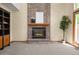 Brick fireplace with a wooden mantle, flanked by built-in shelves and a large plant at 6506 S Robb Way, Littleton, CO 80127