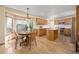 Kitchen with wooden cabinets, an island, stainless steel appliances, and a dining area by a window at 6506 S Robb Way, Littleton, CO 80127