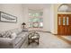 Bright living room featuring a bay window, a comfortable couch, and neutral decor at 6506 S Robb Way, Littleton, CO 80127