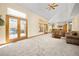 Open-concept living room with large windows, double doors, and seamlessly connects to the kitchen at 6506 S Robb Way, Littleton, CO 80127