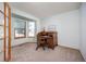 Bright home office featuring a wooden roll top desk, bay window, and neutral carpet at 6506 S Robb Way, Littleton, CO 80127