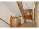 Wooden staircase with carpeted steps, leading to an arched entryway with a wooden front door at 6506 S Robb Way, Littleton, CO 80127