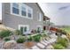 Landscaped backyard with stone pathway, garden beds, and a view of the home's exterior at 6930 Hyland Hills St, Castle Pines, CO 80108