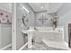 Serene bathroom featuring a soaking tub with marble surround and pedestal sink at 6930 Hyland Hills St, Castle Pines, CO 80108