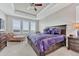 Serene bedroom boasts a tray ceiling, plush bedding, and ample natural light from large windows at 6930 Hyland Hills St, Castle Pines, CO 80108