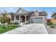 Beautiful home with a covered porch, stone accents, and two-car garage offering modern curb appeal at 6930 Hyland Hills St, Castle Pines, CO 80108