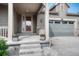 Inviting front porch leading to the entrance and a view of the attached garage at 6930 Hyland Hills St, Castle Pines, CO 80108