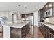 Spacious kitchen with a granite island, dark wood cabinetry, and stainless steel appliances at 6930 Hyland Hills St, Castle Pines, CO 80108