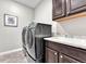 Modern laundry room featuring a front-load washer and dryer and cabinet space at 6930 Hyland Hills St, Castle Pines, CO 80108