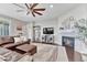 Cozy living room featuring a fireplace, comfortable seating, and a ceiling fan for added comfort at 6930 Hyland Hills St, Castle Pines, CO 80108