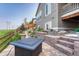 Stone patio with outdoor fire pit, complemented by manicured landscaping and backyard views at 6930 Hyland Hills St, Castle Pines, CO 80108
