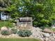 Community sign for Woodstream Falls with lush landscaping and stone accents at 9995 E Harvard Ave # 177, Denver, CO 80231