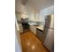 Galley kitchen featuring stainless steel appliances, white cabinets, and tiled backsplash at 9995 E Harvard Ave # 177, Denver, CO 80231