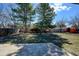 Large backyard with a stone patio, mature trees, a small playhouse, and a wooden fence at 7476 Park Lane Rd, Longmont, CO 80503