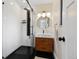 Modern bathroom features a glass shower, black hardware, wood vanity, and sink at 7476 Park Lane Rd, Longmont, CO 80503